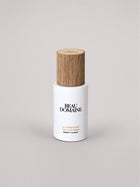 Flacon de Soins avec bouchon en bois sur fond gris clair