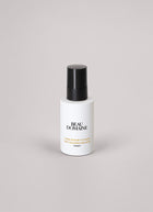 Flacon blanc The Cleansing Emimsop avec bouchon noir portant la mention « Beau Domaine » sur un fond gris clair